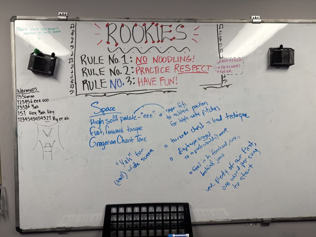Whiteboard notes from a false-cord screaming lesson: vowel shapes, larynx position, diaphragm engagement, and tongue placement annotations.